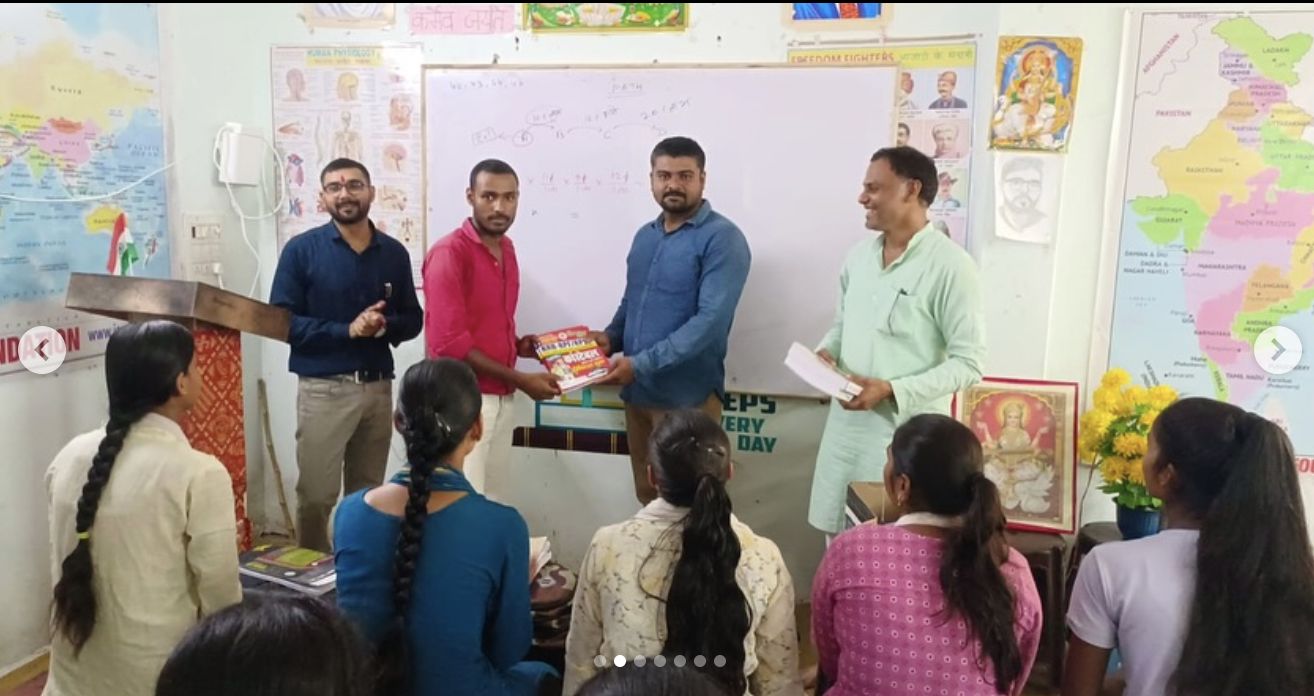 Jana Vidya Foundation volunteers distributing books in a classroom in Prayagraj